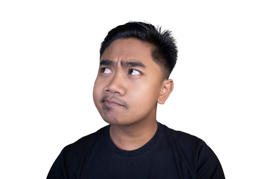 Young man gazes upward, frowning thoughtfully. His expression shows confusion or puzzlement. Simple black t-shirt contrasts with stark white background.