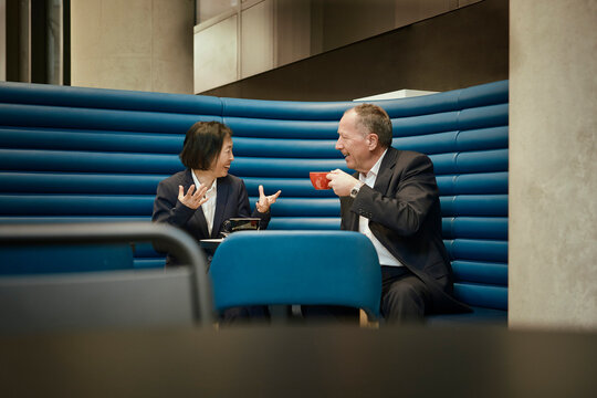 Businessman and businesswoman drink coffee in a coffee shop