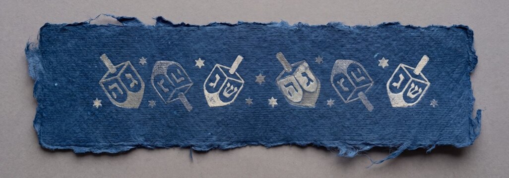 A textured blue Hanukkah dreidel banner adorned with festive symbols and Hebrew letters, meticulously crafted and evoking a sense of traditional celebration.