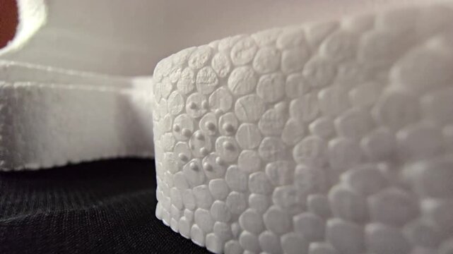 Detailed macro shot of a white styrofoam block corner edge with shallow depth of field. Ideal for product packaging and 3D material close-ups.