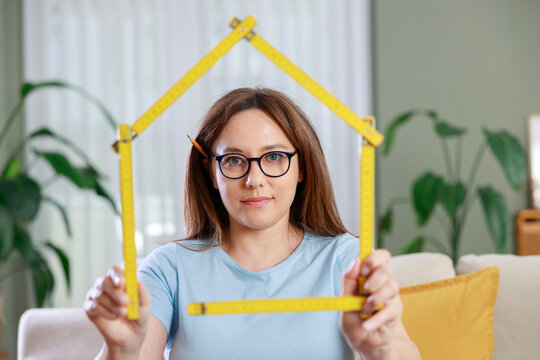 Young woman framing head with folding ruler
