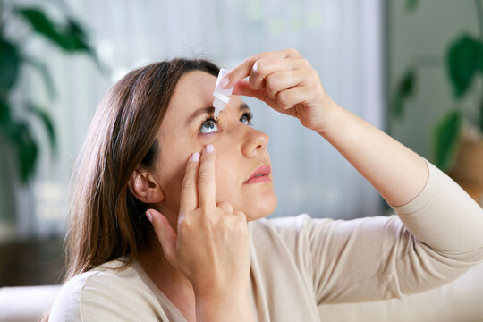 Young woman putting eye drops