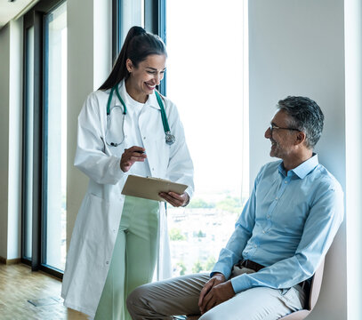 Smiling female doctor gives advice to a male patient at the hospital