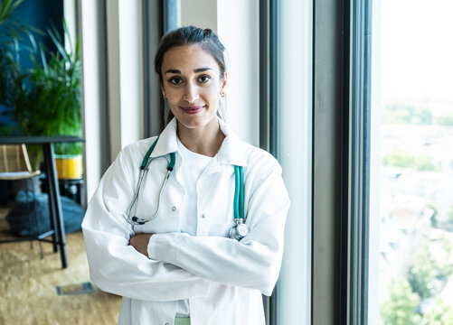 A smiling female doctor wears a stethoscope in the office