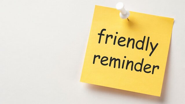 A yellow sticky note pinned with a thumbtack and handwritten friendly reminder text. Perfect for office organization and time management concepts.