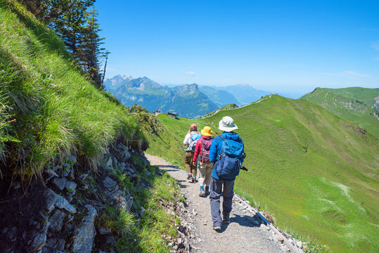 three mountaineers at ridge trail from Klingenstock to Fronalpstock mountain, swiss alps