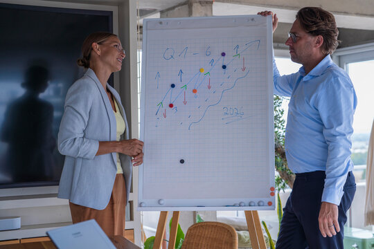 Businessman and businesswoman discuss strategy at the office