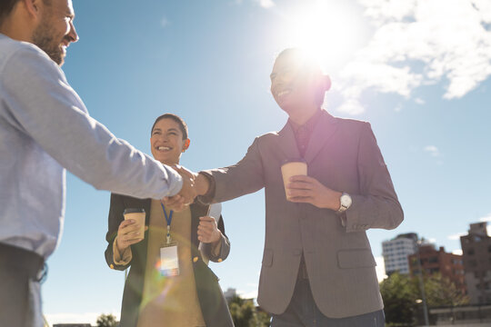 Business people shake hands outdoors for a corporate partnership