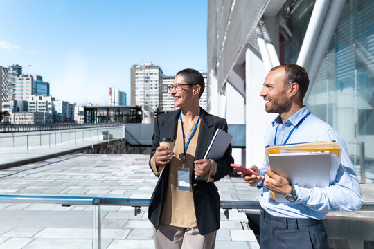 A businessman and woman enjoy a coffee break outside the office