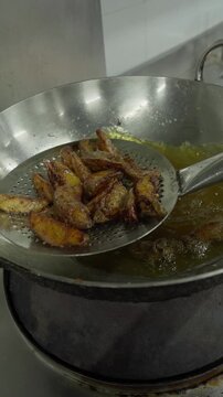 Chef Lifting and Draining Crispy Fried Potato Wedges - Vertical Video