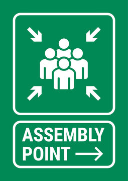 Green assembly point safety sign indicating the designated emergency gathering area where people should meet during evacuation procedures.
