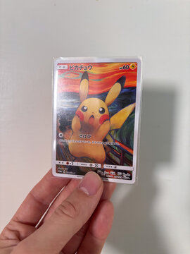 Hamburg, Germany - 09052026: male hand holding fake Pikachu Munch Exhibition PROMO card, fan made paper trading card.
