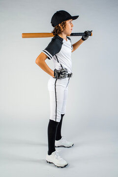 Full length profile shot of a youth baseball player standing with bat on shoulder and hand on hip