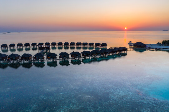 Maldives, Olhuveli island, Resort bungalows on South Male Atoll lagoon at sunset