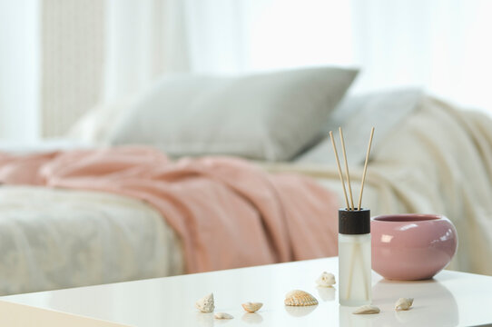 Aromatheraphy and incense sticks on table with bed in background