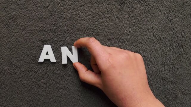 the word anemia written with white capital letters in a gray textured background (slow version)
