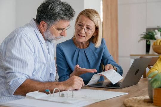Couple discussing financial problems at home while checking bills