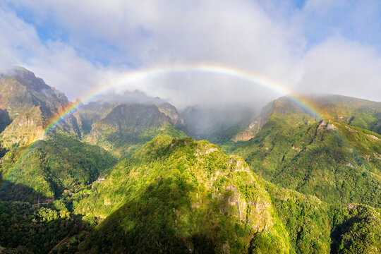 Rainbow over lush mountains at Miradouro dos Balc�es Madeira Portugal