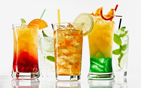 Glasses of cocktail with straw and fruit on white background