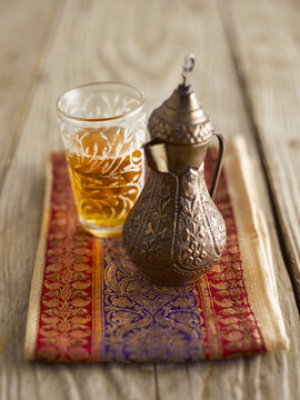 Traditional Turkish tea in glass and ornate metal teapot on wood