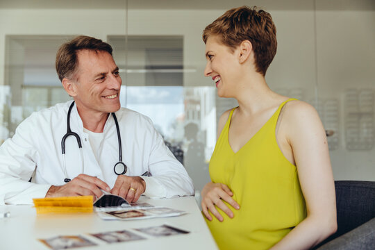 Pregnant woman discussing ultrasonic scans with her doctor
