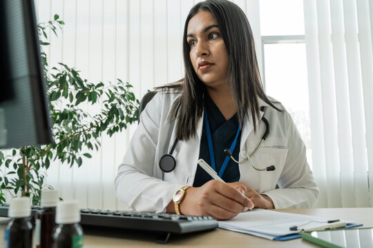 Female doctor writes a medical prescription at the hospital desk