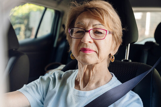 Woman wearing a seatbelt drives an electro car