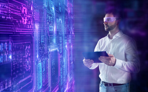 Businessman analyzes data on a futuristic screen with a tablet