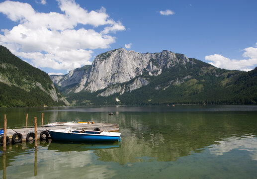 Austria, Salzkammergut, Ausseerland, Altaussee, View of boats in altausseer see lake near tressenstein mountain