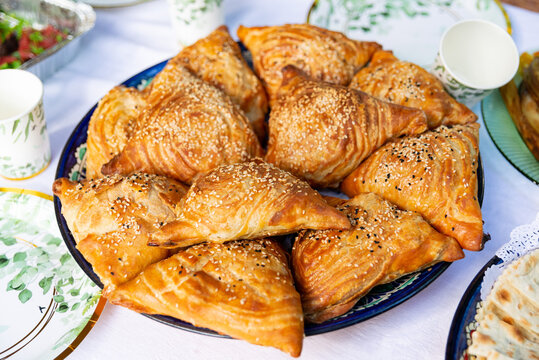 Golden triangular samsa pastries with sesame seeds