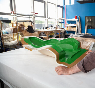 green matrix of a car seat on a white table in a workshop
