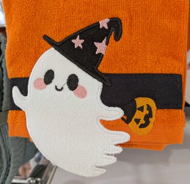 Tiempo de Halloween. Vista de cerca de una toalla o pa&ntilde;o de cocina con un simp&aacute;tico fantasma con sombrero de bruja y calabaza de Halloween para recoger dulces, en el expositor de una tienda 