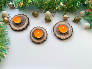 A Christmas arrangement with candles on wooden spires and tinsel. © fotorybalka