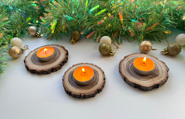 A Christmas arrangement with candles on wooden spires and tinsel. © fotorybalka