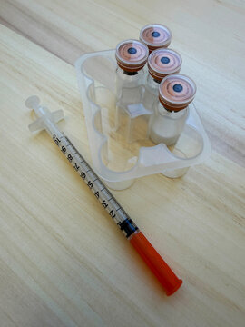 Reta, retatrutide peptide in a vial and bacteriostatic water on a wooden background