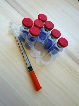 GHK-Cu, copper tripeptide in a vial and bacteriostatic water on a wooden background.