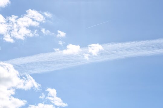 Airplane contrails and white clouds in blue sky background for sky replacement