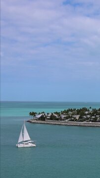 Key West Florida. Panoramic view of a sailboat sailing on clear turquoise ocean water near Sunset Key