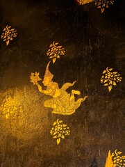 Close up of traditional Thai golden mural painting of a Deva angel on a dark textured background at Wat Phra Phuttha Chinnarat, Thailand. © PONGSIRI PECHARAT