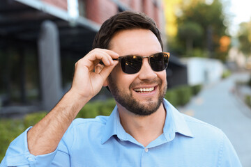 Obraz premium Handsome man wearing stylish sunglasses on city street