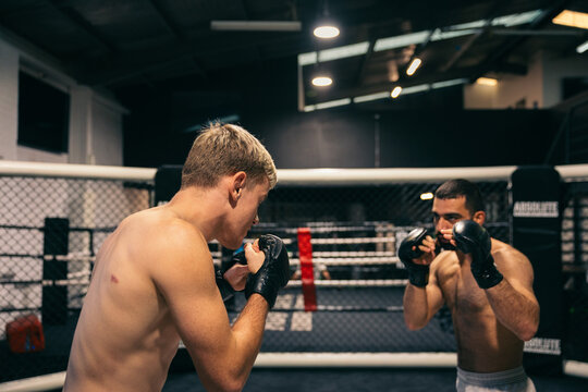 Intense MMA cage sparring between two athletes