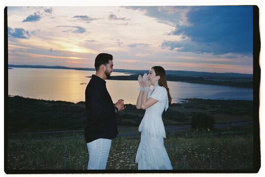 Woman Reacting to Marriage Proposal at Sunset by the Lake