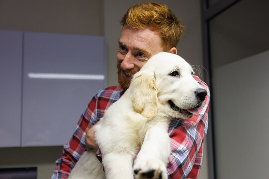 Joyful owner keeping dog in arms and waiting for doctor's appointment