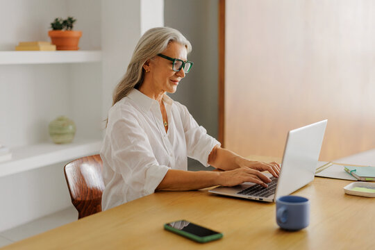 Senior woman working remotely using laptop at home