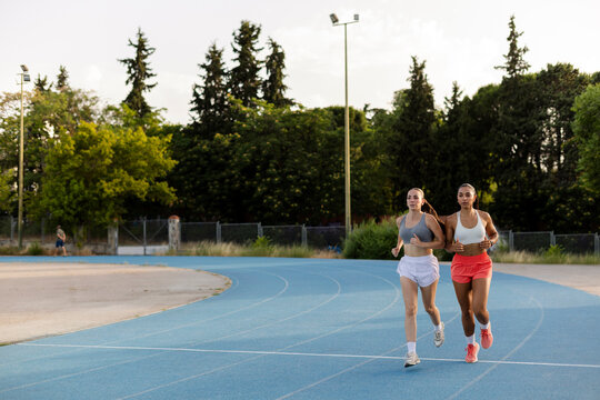 Female athletes running on track for fitness workout