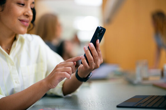 Woman Using Smartphone at Office Desk