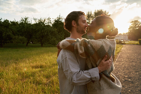 Couple embraces in a park during sunset