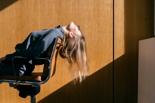Businesswoman Resting Back in Office Chair in Sunlight