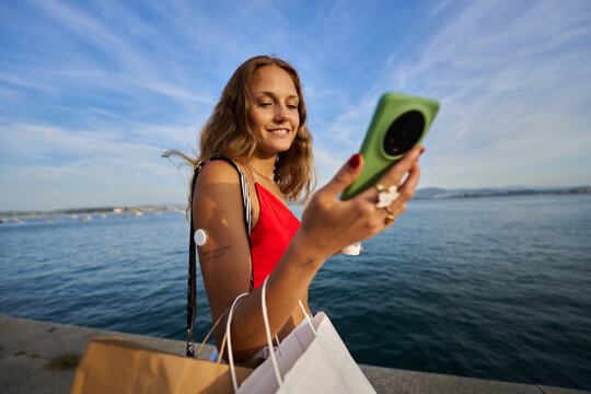 Woman checking glucose levels with smartphone after shopping