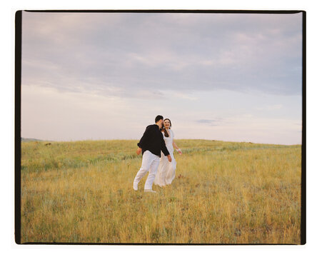 Couple Walking Together Across Grassy Hillside